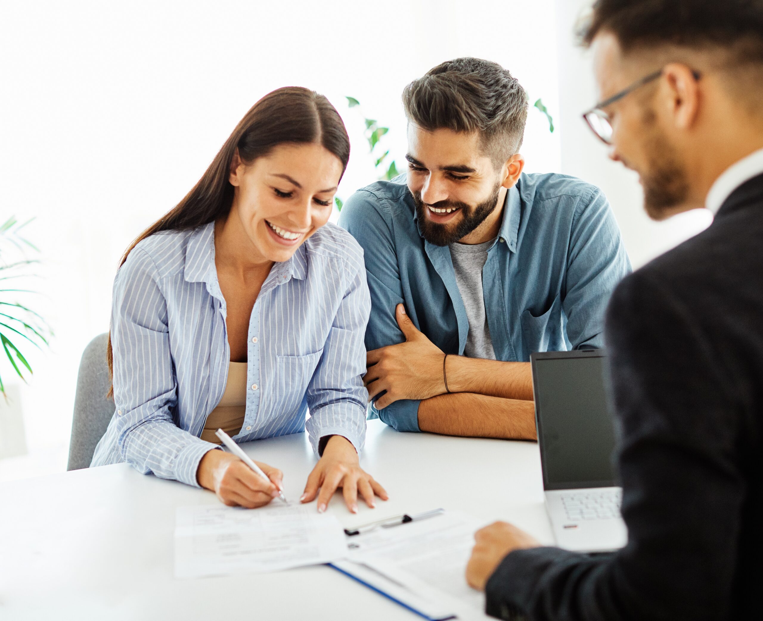 Real estate agent with couple closing a deal and signing a contract;