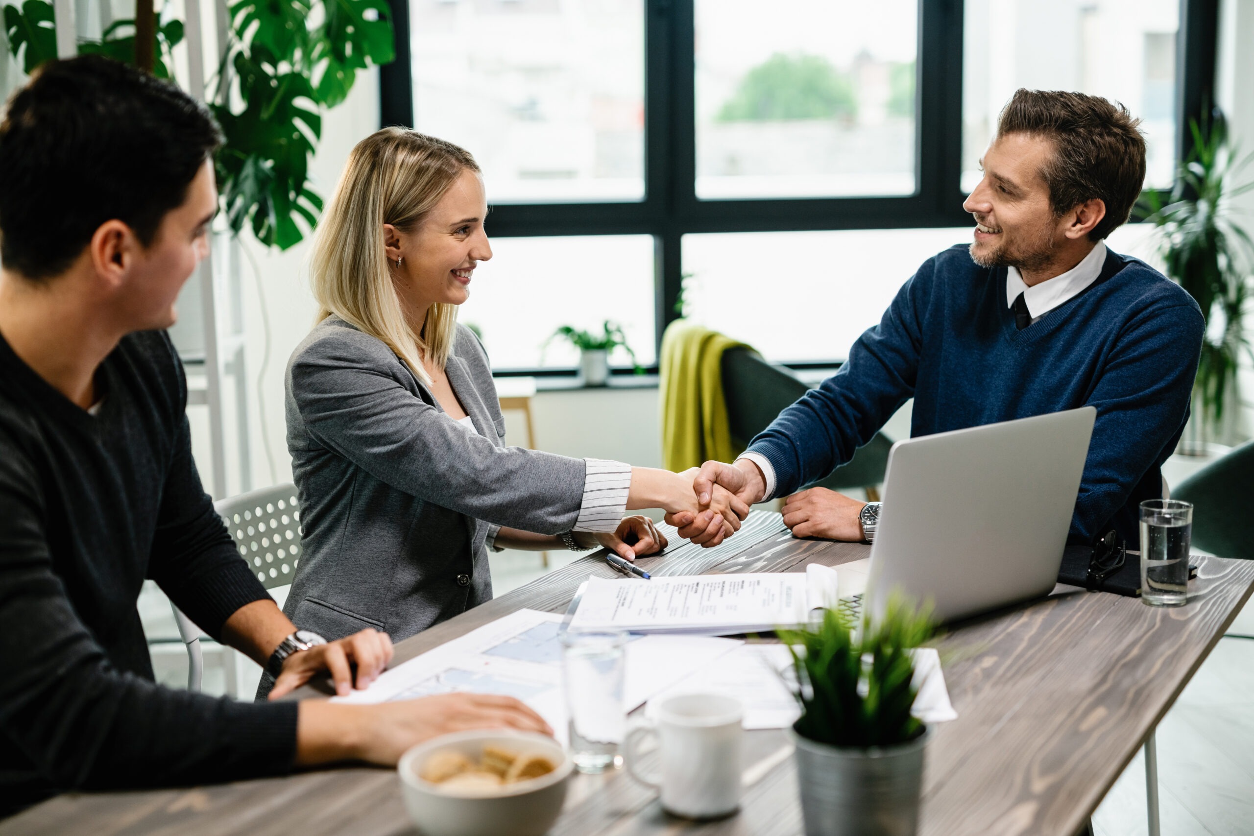 Young happy couple meeting with financial advisor in the office.